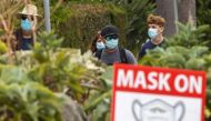 FILE PHOTO: People wear masks as they walk along the side walk in Del Mar, Calif., on July 30, 2020. Mike Blake/Reuters/File Photo
