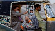 People with masks against COVID-19 travel by rikshaw (tok tok) in Karachi, Pakistan January 25, 2021. REUTERS/Akhtar Soomro
