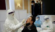 A health worker takes a sample for a coronavirus test from a journalist in preparation for the 13th National Congress of the Communist Party of Vietnam, which began on January 25, in Hanoi, Vietnam, January 18, 2021. REUTERS/Kham/File Photo