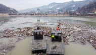 Workers collect plastic trash that litters the polluted Potpecko Lake near a dam's hydroelectric plant near the town of Priboj, Serbia, January 29, 2021. Picture taken with a drone. REUTERS/Marko Djurica