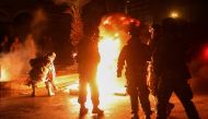 Members of the Lebanese army stand near burning tires during a protest against the lockdown and worsening economic conditions, amid the spread of the coronavirus disease (COVID-19), in Tripoli, Lebanon January 29, 2021. REUTERS/Mohamed Azakir