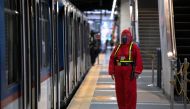 A security guard wearing a hazmat suit for protection against the coronavirus disease (COVID-19) stands beside a train in Manila, Philippines, January 29, 2021. REUTERS/Eloisa Lopez