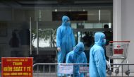 FILE PHOTO: Medical workers in protective suits stand outside a quarantined building amid the coronavirus disease (COVID-19) outbreak in Hanoi, Vietnam, January 29, 2021. REUTERS/Thanh Hue