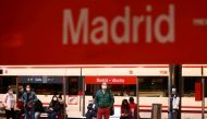 FILE PHOTO: Commuters wearing protective face masks wait on a platform at Atocha train station during a partial lockdown amid the outbreak of the coronavirus disease (COVID-19), in Madrid, Spain October 5, 2020. REUTERS/Sergio Perez