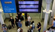 FILE PHOTO: Passengers wearing protective face masks arrive from Paris at Eurostar terminal at St Pancras station, as Britain imposes a 14-day quarantine on arrival from France from Saturday, following the outbreak of the coronavirus disease (COVID-19), i