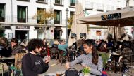 French visitors Theo Perucci and his sister Luna play cards while enjoying a meal on a terrace during their week on holiday as the coronavirus disease (COVID-19) pandemic continues in Madrid, Spain, February 5, 2021. Picture taken February 5, 2021. REUTER