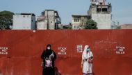 FILE PHOTO: Two Muslim women wearing protective masks stand on a side of the main road, in Colombo, Sri Lanka April 1, 2020. Dinuka Liyanawatte/Reuters
