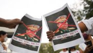 People hold pictures of Myanmar's army chief Min Aung Hlaing with his face crossed out as Myanmar citizens protest against the military coup in Myanmar outside United Nations venue in Bangkok, Thailand February 6, 2021. REUTERS/Chalinee Thirasupa