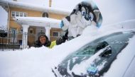 Francisco Sanchez wipes snow off his car with a boogie board before going out sledding with his kids on Valentine's Day at Memorial Park in El Paso, Texas, U.S. February 14, 2021. Briana Sanchez/El Paso Times/USA Today Network via REUTERS. 