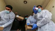Palestinian workers unload the first shipment of coronavirus disease (COVID-19) vaccines, in the southern Gaza Strip February February 17, 2021. REUTERS/Ibraheem Abu Mustafa