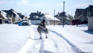 A man walks to his friend's home in a neighborhood without electricity as snow covers the BlackHawk neighborhood in Pflugerville, Texas, U.S. February 15, 2021. Bronte Wittpenn