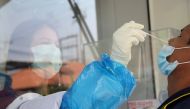 A healthcare worker takes a nasal swab sample from a migrant worker during proactive testing at their work place, amid the spread of the coronavirus disease (COVID-19) outbreak, in Samut Sakhon province, Thailand January 29, 2021. REUTERS/Soe Zeya Tun/Fil