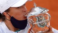 Poland's Iga Swiatek kisses the trophy as she celebrates after winning the French Open. REUTERS/Christian Hartmann/File Photo