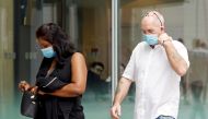 Briton Skea Nigel and partner Agatha Maghesh Eyamalai arrive at the State Courts for a hearing after breaking coronavirus disease (COVID-19) quarantine regulations in Singapore February 15, 2021.  REUTERS/Edgar Su
