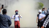 Protesters flee from teargas during a rally against the military coup in Yangon, Myanmar, February 27, 2021. REUTERS/Stringer