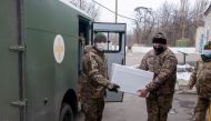 FILE PHOTO: Ukrainian servicemen carry a box with the Oxford-AstraZeneca vaccine against the coronavirus disease (COVID-19) at a mobile military hospital in the town of Pokrovsk in Donetsk Region, in this handout picture released February 25, 2021. Press 