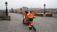 : A man wearing a face mask cleans the empty Charles Bridge as the Czech government-mandated further restrictions to curb the spread of the coronavirus disease (COVID-19) in Prague, Czech Republic, March 1, 2021. REUTERS/David W Cerny
