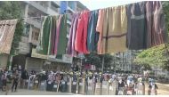 Traditional clothes hang on a rope as protesters holding shields stand in line in the background during a protest against the military coup in Yangon, Myanmar March 6, 2021 in this still image obtained by Reuters from a video.