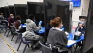Health workers and volunteers assist as students take coronavirus disease (COVID-19) tests at Harris Academy Beckenham, ahead of full school reopening in England as part of lockdown restrictions being eased, in Beckenham, south east London, Britain, March