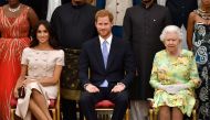 FILE PHOTO: Britain's Queen Elizabeth, Prince Harry and Meghan, the Duchess of Sussex pose for a picture with some of Queen's Young Leaders at a Buckingham Palace reception following the final Queen's Young Leaders Awards Ceremony, in London, Britain June