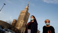 People wearing protective masks amid the outbreak of coronavirus disease (COVID-19) walk in front of the Palace of Culture and Science in the centre of Warsaw, Poland February 24, 2021. REUTERS/Kacper Pempel/File Photo