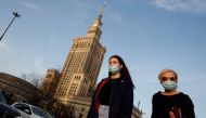 People wearing protective masks amid the outbreak of coronavirus disease (COVID-19) walk in front of the Palace of Culture and Science in the centre of Warsaw, Poland February 24, 2021. REUTERS/Kacper Pempel/File Photo