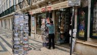 A man organizes newspapers in front of a store in Lisbon downtown amid the coronavirus disease (COVID-19) pandemic, in Lisbon, Portugal, March 11, 2021. REUTERS/Pedro Nunes
