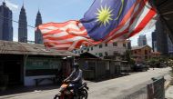FILE PHOTO: A man wearing a protective mask rides across a street, during a lockdown due to the coronavirus disease (COVID-19) outbreak, in Kuala Lumpur, Malaysia February 2, 2021. REUTERS/Lim Huey Teng/File Photo
