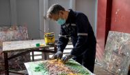 Filipino artist Gilbert Angeles incorporates expired paint and shredded plastic wrappers into a painting he is working on, at his studio in Plaridel, Bulacan province, Philippines, February 8, 2021. Picture taken February 8, 2021. REUTERS/Eloisa Lopez