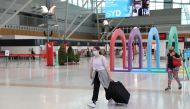 File photo: People wearing masks walk through a mostly empty domestic terminal at Sydney Airport in Sydney, Australia, December 21, 2020. Reuters/Loren Elliott/File Photo