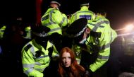 Police detain a woman as people gather at a memorial site in Clapham Common Bandstand, following the kidnap and murder of Sarah Everard, in London, Britain March 13, 2021. Reuters/Hannah McKay