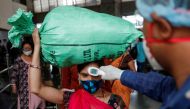 A health worker checks the temperature of a passenger, amid the spread of the coronavirus disease (COVID-19), at a railway station in Mumbai, India, March 17, 2021. REUTERS/Francis Mascarenhas