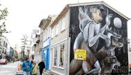 People walk past artwork on the side of a shop as the outbreak of the coronavirus disease (COVID-19) continues in Reykjavik, Iceland, September 3, 2020. REUTERS/John Sibley/File Photo