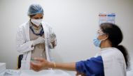 A woman watches as a healthcare worker fills a syringe with a dose of COVISHIELD, the coronavirus disease (COVID-19) vaccine manufactured by Serum Institute of India, at Max Super Speciality Hospital, in New Delhi, India, March 17, 2021. REUTERS/Adnan Abi