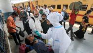 A health worker in personal protective equipment (PPE) collects a swab sample from a woman during a rapid antigen testing campaign for the coronavirus disease (COVID-19), at a railway station platform in Mumbai, India, March 17, 2021. REUTERS/Francis Masc