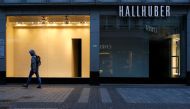 A man walks along a closed shop at the main shopping street Hohe Strasse amid the coronavirus disease (COVID-19) pandemic in Cologne, Germany, March 18, 2021. Picture taken March 18, 2021. REUTERS/Thilo Schmuelgen
