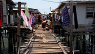 File photo: A woman washes clothes on a wooden path between stilt houses at Hanuabada Village, located in Port Moresby Harbour, Papua New Guinea, November 19, 2018. Reuters/David Gray/File Photo