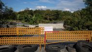A makeshift barrier is placed near a concrete wall built in the middle of a road for security and safety concerns from a nearby prison amid the coronavirus disease (COVID-19) outbreak, in Muntinlupa, Metro Manila, Philippines, March 22, 2021. REUTERS/Eloi