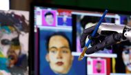 Humanoid robot Sophia, developed by Hanson Robotics, holds a brush during a demonstration before her non-fungible token (NFT) artwork is auctioned, in Hong Kong, China March 16, 2021. Picture taken March 16, 2021. REUTERS/Tyrone Siu