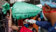 A health worker checks the temperature of a passenger, amid the spread of the coronavirus disease (COVID-19), at a railway station in Mumbai, India, March 17, 2021. REUTERS/Francis Mascarenhas
