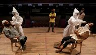 Healthcare workers wearing personal protective equipment (PPE) collect swab samples from men during a rapid antigen testing campaign for the coronavirus disease (COVID-19), at an auditorium turned into a testing centre in Ahmedabad, India, March 23, 2021.
