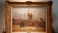 Sotheby's Paris employees pose with the 1887 painting of a Paris street scene 