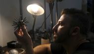 Argentine artist Marcelo Toledo works on an art piece depicting a coronavirus virion made from iron that will be part of the 
