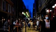 FILE PHOTO: People wearing protective masks walk past bar customers after bars reopened in Spain's Basque Country, amid the coronavirus disease (COVID-19) outbreak, in Bilbao, Spain, February 19, 2021. REUTERS/Vincent West