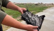 A spectator holds a piece of debris which was blown 5 miles (8 km) from the site where SpaceX test rocket SN11 exploded upon landing, in Boca Chica, Texas, U.S. March 30, 2021. REUTERS/Gene Blevins
