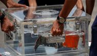 National Transportation Safety Committee (KNKT) officials place the Cockpit Voice Recorder (CVR) of Sriwijaya Air flight SJ 182 on a table at Tanjung Priok Port in Jakarta, Indonesia, March 31, 2021. Reuters/Willy Kurniawan