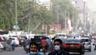 Men wear protective masks as they walk along a road, amid the outbreak of coronavirus disease (COVID-19) in Karachi, Pakistan March 30, 2021. REUTERS/Akhtar Soomro
