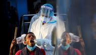 File photo: A healthcare worker collects a coronavirus disease (COVID-19) test swab sample from a man, at a temporary shelter for homeless people in New Delhi, India, March 31, 2021. Reuters/Adnan Abidi/File Photo