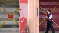A man wearing a protective mask walks past closed shops, amid the coronavirus disease (COVID-19) outbreak in Kuala Lumpur, Malaysia May 28, 2020. REUTERS/ Lim Huey Teng/File Photo