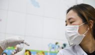 A doctor looks at the vial before receiving a vaccine, as Vietnam starts its official rollout of AstraZeneca's coronavirus disease (COVID-19) vaccine for health workers, at Hai Duong Hospital for Tropical Diseases, Hai Duong province, Vietnam, March 8, 20